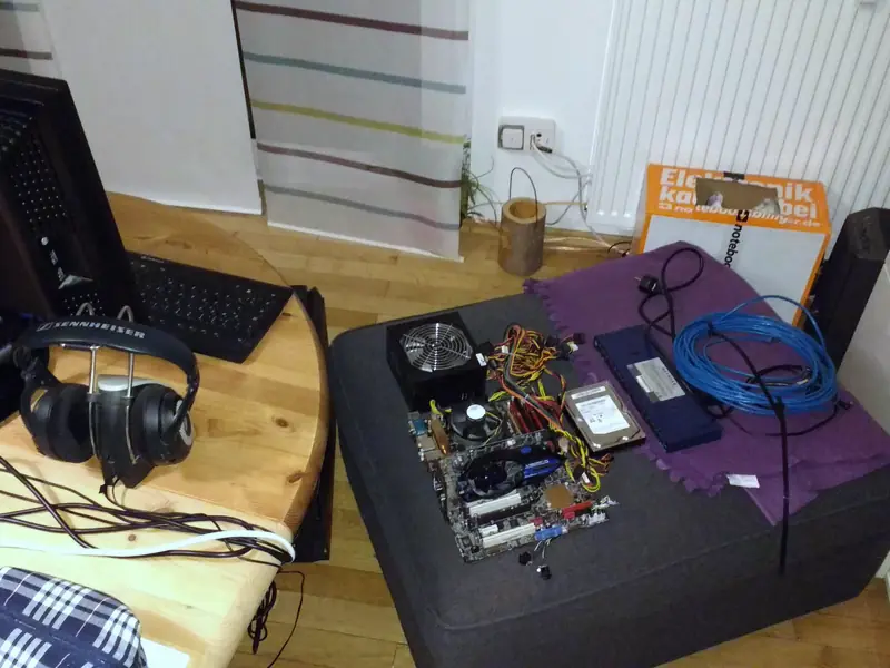 Aufbau: Mainboard, Netzteil und Netzwerkkabel auf dem Hocker