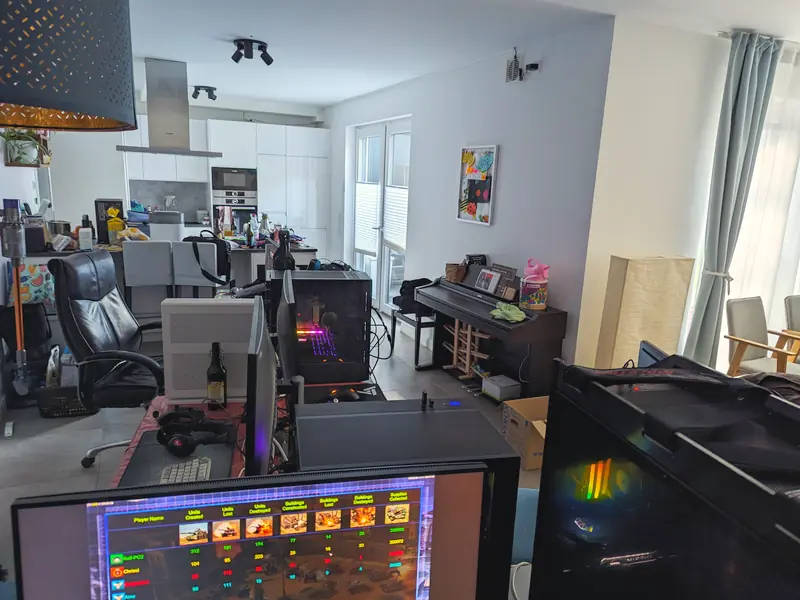 Wohnzimmer mit Plätzen, vorne ein Monitor mit Spielmenü